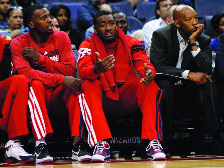 Ann Heisenfelt/AP
Wizards guard John Wall, center, is not expected back until at least early next month because of a stress injury in his left knee, though an MRI showed he's healing.