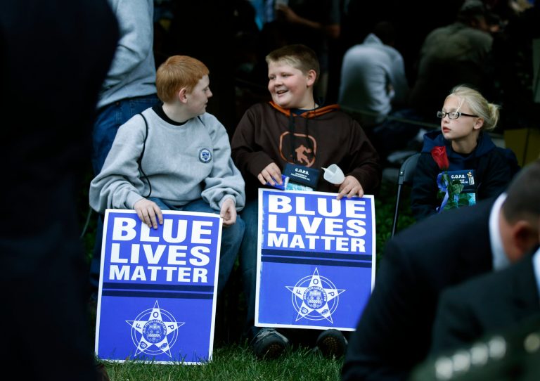 Two boys hold signs that say 