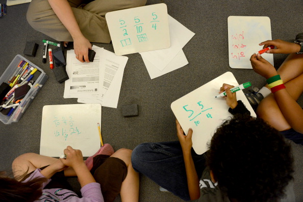 Teacher Veronica Munoz goes over fractions with her students in fourth grade math class at Piney Branch Elementary School in Takoma Park, MD on May 16, 2013. (Photo by Linda Davidson / The Washington Post via Getty images)