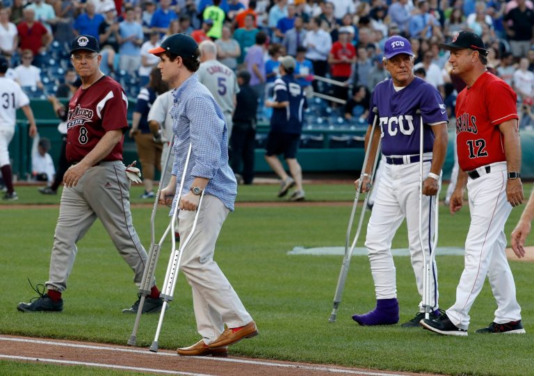 Injured aide Zach Barth, left, and Rep. Roger Williams, R-Texas, also on crutches walk off the field before the Congressional baseball game, Thursday, June 15, 2017, in Washington. The annual GOP-Democrats baseball game raises money for charity. (AP Photo/Alex Brandon)