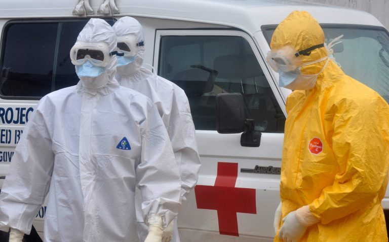 Health workers in protective gear wait to carry a body of a person suspected to have died from Ebola not in frame   Monrovia ,Liberia. Monday, Oct. 13, 2014. Some nurses in Liberia defied calls for a strike on Monday and turned up for work at hospitals amid the worst Ebola outbreak in history. In view of the danger of their work, members of the National Health Workers Association are demanding higher monthly hazard pay. The association has more than 10,000 members, though the health ministry says only about 1,000 of those are employed at sites receiving Ebola patients. (AP Photo/ Abbas Dulleh)