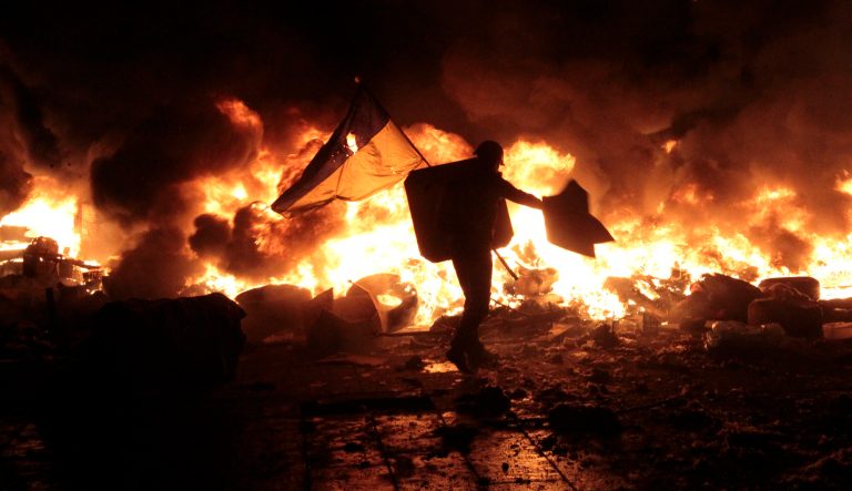 Anti-government protesters clash with riot police in Kiev's Independence Square, the epicenter of the country's current unrest, Kiev, Ukraine, Tuesday, Feb. 18, 2014. Thousands of police armed with stun grenades and water cannons attacked the large opposition camp in Ukraine's capital that has been the center of nearly three months of anti-government protests on Tuesday, after at least nine people were killed in street clashes.  (AP Photo/Sergei Chuzavkov)