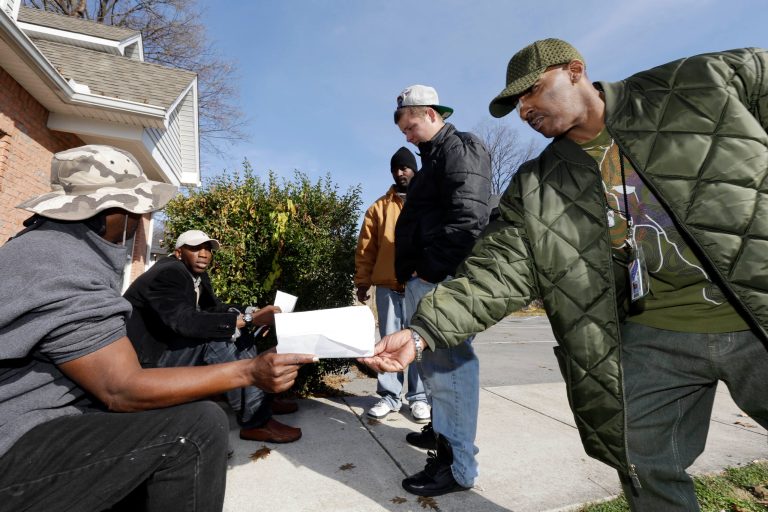   In this Nov. 29, 2012 photo, Kerry Rankins, right, hands a paper to Racinto Lester, left, as a group of former employees of the Veterans Support Organization talk outside the organization's closed office in Nashville, Tenn. The Stuart, Fla.-based Veterans Support Organization had been fined by Tennessee for making false claims about the benefits it offered, and Connecticut lawmakers called for a federal investigation before the groupâs Tennessee branch closed last month. (AP Photo/Mark Humphrey)  