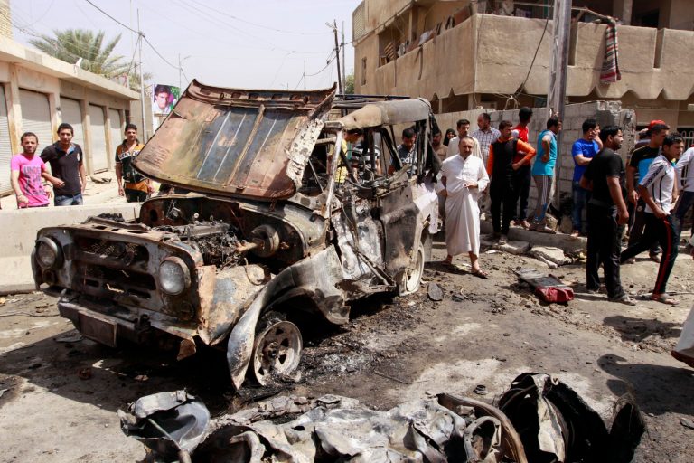 Civilians gather at the scene of a car bomb attack in the east Baghdad neighborhood of Kamaliya, Iraq, Monday, April 15, 2013. A series of attacks across, Iraq many involving car bombs, has killed and wounded dozens of people, police said less than a week before Iraqis in much of the country are scheduled to vote in the country's first elections since the 2011 U.S. troop withdrawal. (AP Photo/ Khalid Mohammed)