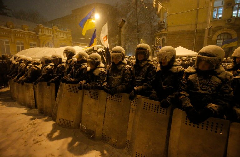 Ukrainian riot police block Pro-European Union activists' tent camp next to the Ukrainian Government buildings in Kiev, Ukraine, Monday, Dec. 9, 2013. Hundreds of police in full riot gear flooded into the center of Kiev on Monday as mass anti-government protests gripped the Ukrainian capital for yet another week, raising fears of an imminent crackdown. (AP Photo/Sergei Grits)