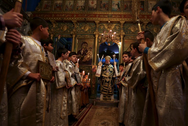 Palestinian Orthodox Christians celebrate Palm Sunday at Gaza's Church of Saint Porphyrius, named after the 5th century bishop of Gaza, in Gaza City, Sunday, April 13, 2014.  Palm Sunday marks for Christians, Jesus Christ's entrance into Jerusalem, when his followers laid palm branches in his path. There are approximately 2500 Christians among an overall  Palestinian population of more than 1.7 million in Gaza. (AP Photo/Hatem Moussa)
