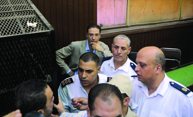 Islam Afifi, the chief editor of el-Dustour newspaper, center, attends a court hearing in Cairo, Egypt, Thursday, Aug. 23, 2012. A Cairo court on Thursday ordered the chief editor of an Egyptian newspaper detained pending trial on charges of insulting the country's president and 