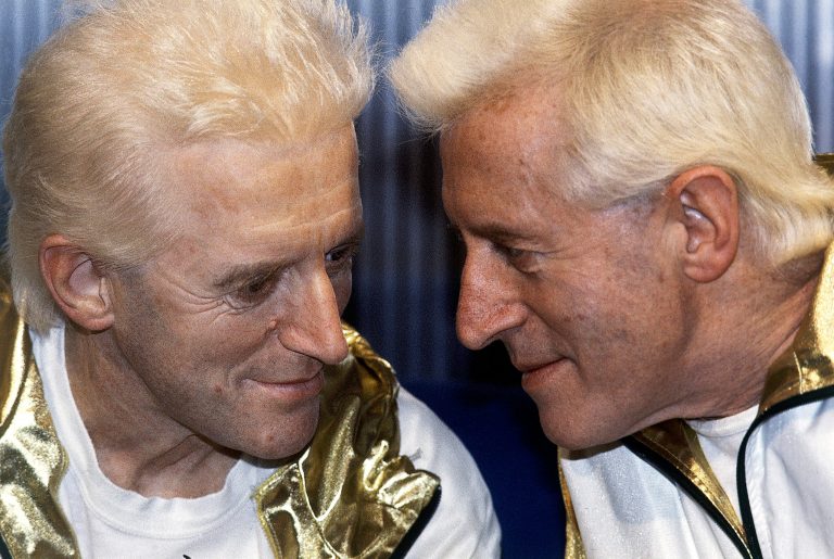   FILE - In this Dec. 17, 1986 file photo, Jimmy Savile, right, poses for photographers with a wax work model at Madame Tussauds museum in London. British police investigating sex abuse allegations against the late BBC entertainer Jimmy Savile say that they have recorded 199 crimes in which Savile is a suspect. In an update on its investigation, Scotland Yard said Wednesday Dec. 12, 2012 that 450 people have come forward with information relating to the children's television presenter, who died last year at age 84. Most of those people have alleged sexual abuse, and there were 31 rape allegations recorded against Savile, police said. (AP Photo/John Redman, File)  