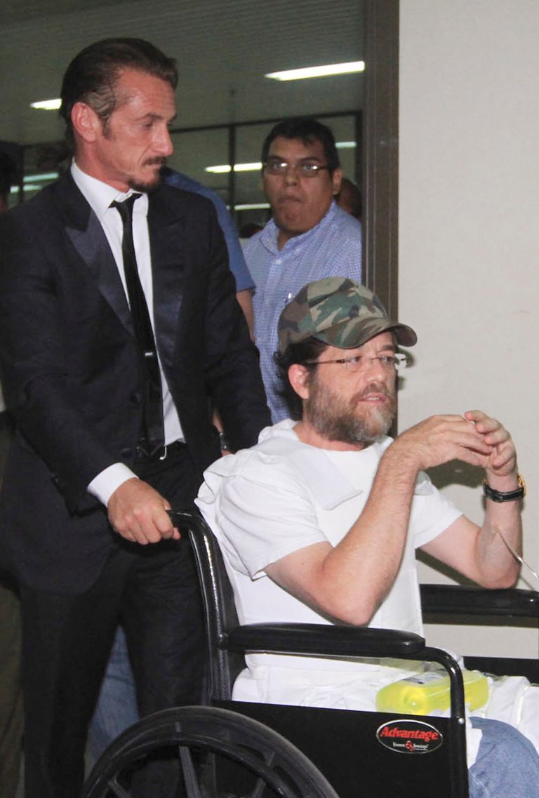   U.S. actor Sean Penn pushes U.S. businessman Jacob Ostreicher in a wheelchair, wearing a flak jacket, during a recess at Ostreicher's hearing in Santa Cruz, Bolivia, Tuesday, Dec. 11, 2012. A Bolivian appeals panel has refused to immediately release Ostreicher, despite evidence he was fleeced and extorted by prosecutors who have had him jailed for 18 months without charges on suspicion of money laundering. Ostreicher has been hospitalized for more than two weeks in a private clinic after being diagnosed with Parkinson's. Ostreicher's case led to the uncovering of a shakedown ring allegedly run by the No. 1 legal advisor in the Interior Ministry, and including two prosecutors. It came after actor Sean Pean interceded with President Evo Morales. (AP Photo)  