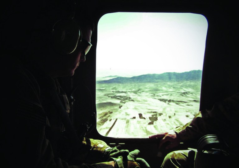 This photo taken Oct. 10, 2012 shows Army Brig. Gen. John Charlton, left, riding in a Blackhawk helicopter in eastern Afghanistan. A new chapter of the Afghanistan war is opening with a slimmed-down Western force doing more advising than fighting, a resilient Taliban showing little interest in peace talks, and Americans tempted to pull the plug on a conflict now in its 12th year. A decisive end seems nowhere in sight. (AP Photo/Robert Burns)