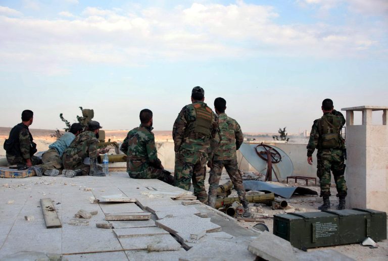 In this photo released by the Syrian official news agency SANA, Syrian government soldiers stand guard on the roof of Aleppo prison in Aleppo, Syria, Thursday, May 22, 2014. Syrian troops backed by airstrikes broke a yearlong rebel siege of a prison in the northern city of Aleppo Thursday, allowing President Bashar Assad's forces to close in on a nearby command center of a coalition of Islamist rebel groups, opposition activists said. (AP Photo/SANA)
