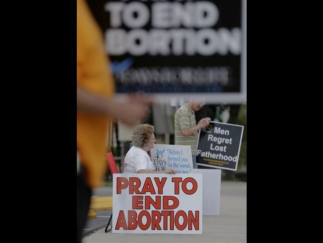 In this Oct. 29, 2013 file photo, Dottie and Tom Knodell, opponents of abortion, hold signs outside a Planned Parenthood Clinic, in San Antonio. AP Photo/Eric Gay