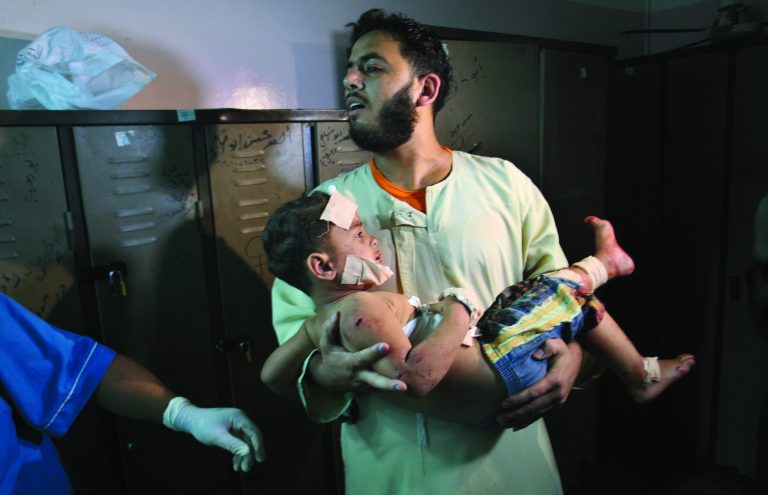 A Palestinian man carries a wounded boy in Al Najar Hospital following an Israeli air strike in Rafah, southern Gaza Strip, Sunday, Oct. 7, 2012. Israel's military says it has fired on two Gaza members of an al-Qaida-inspired group identified as having been involved in rocket attacks and an infiltration from Egypt. Palestinians say one man was killed. The military said they were involved in 