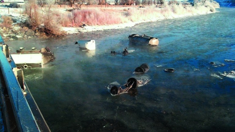 This photo provided by Hanser's Automotive shows pieces of two trailers that went into the Clarks Fork River near Belfry, Mont. on Monday, Feb. 11, 2013 spilling an estimated 7,000 gallons of magnesium chloride, a chemical used as road salt. (AP Photo/Hanser's Automotive)