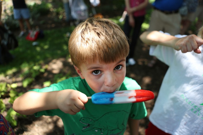 Ian Dowell sucks on a popsicle to overcome the midday heat at the Independence Day parade in downtown Washington on July 4, 2012.