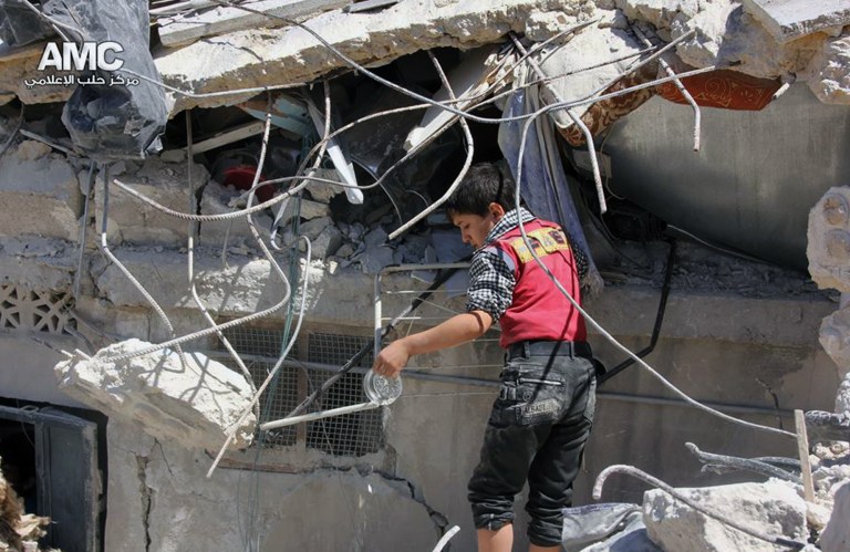 This photo provided by the anti-government activist group Aleppo Media Center (AMC), which has been authenticated based on its contents and other AP reporting, shows a Syrian young inspecting the rubble of houses that were destroyed by airstrikes from the Syrian government forces in Aleppo, Syria, Sunday, May 18, 2014. Syrian rebels captured a village in northwestern Syria on Sunday, killing more than a dozen government troops in heavy clashes and prompting the military to carry out airstrikes to try to dislodge the fighters, activists said. (AP Photo/Aleppo Media Center)