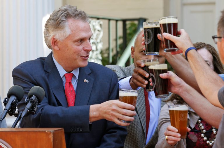 Virginia Gov. Terry McAuliffe makes a toast with members of the Stone Brewing Co. in Richmond as he announces that Stone Brewing Co., one of the nation's top 10 craft breweries, plans to build a facility in Richmond, during a news conference in Richmond, Va., Thursday, Oct. 9, 2014.   (AP Photo/Steve Helber)