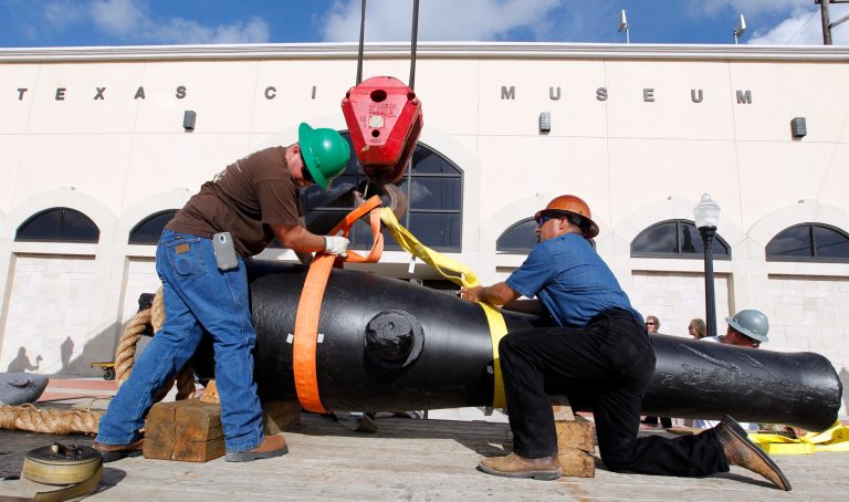 Jimmy Yancey, left, and Rene Del Bosque, both with Domac Inc., secure strapping around the the 11-foot long, 8,400 pound Dahlgren gun as they move it to the Texas City Museum on Wednesday June 18, 2014, in Texas City, Texas.  A Civil War cannon from the 1863 sinking of the USS Westfield has a new resting place at a Texas museum just miles from where the ship went down.   Officials at the Texas City Museum on Wednesday welcomed the restored 12-foot cannon for a maritime exhibit. (AP Photo/The Galveston County Daily News, Jennifer Reynolds) MANDATORY CREDIT; MAGS OUT; TV OUT