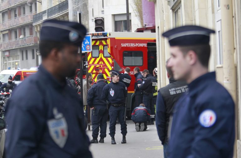 Police officers and rescue workers gather at the scene after gunmen stormed a French newspaper, killing at least 12 people, in Paris, France, Wednesday, Jan. 7, 2015. (AP Photo/Remy de la Mauviniere)