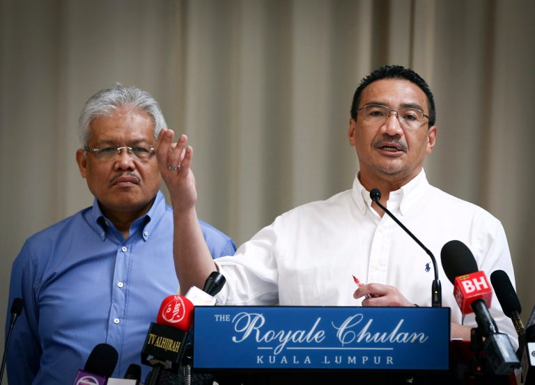 Malaysian Deputy Minister of Foreign Affairs Hamzah Zainudin, left, listens as Malaysia's acting Transport Minister Hishammuddin Hussein answers a question from a journalist during a press conference on the missing Malaysia Airlines Flight 370 at a hotel in Kuala Lumpur, Malaysia, Saturday, April 19, 2014. An underwater robotic submarine is expected to finish searching a narrowed down area of the Indian Ocean seabed for the missing Malaysia Airlines plane within the next week, after completing six missions and so far coming up empty, the search coordination center said Saturday. (AP Photo/Vincent Thian)