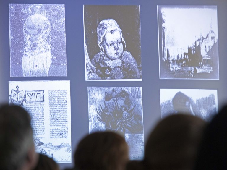   People look at a display of looted art on a video screen as they attend the Provenance Research Training Program to the Nazi-looted art, in Magdeburg, central Germany, Thursday, June 14, 2012. Experts from museums, auction houses, government agencies and other institutions are meeting in Germany this week as part of an international effort to train art-world professionals in issues related to recovering and restituting art and cultural treasures looted during the Nazi era. The six-day conference brings together 35 experts from more than a dozen countries. (AP Photo/Jens Meyer)  