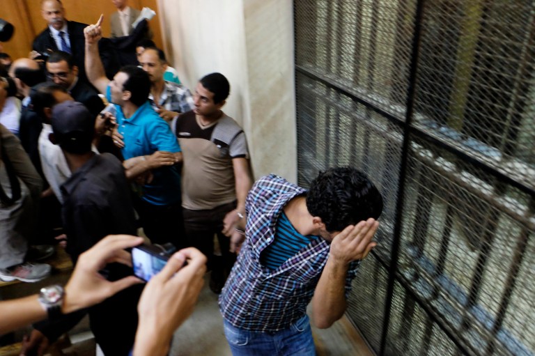 Egyptian men sentenced to life in prison for sexual assaults on women during a number of public rallies in Cairo's iconic Tahrir Square, hide their faces their trial at a court in Cairo, Egypt, Wednesday, July 16, 2014. The court sentenced eight men to prison for sexual violence following the government's decision to toughen penalties. Sexual violence has been on the rise in Egypt, particularly during public gatherings in the past three years. (AP Photo/Aly Hazzaa, El Shorouk) EGYPT OUT