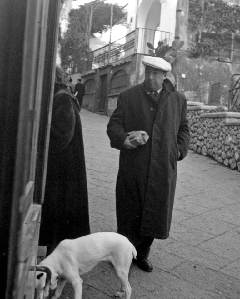 FILE - This Feb. 14, 1952 file photo shows Chilean poet Pablo Neruda in Capri, Italy. Forty years after his death, Pablo Neruda once again was writing and reciting love poems and he walked through Santiago's streets to the admiring gazes of Chileans - virtually, that is. The Nobel Prize-winning poet was briefly visible Friday, July 11, 2014 writing verses in the window of his former home in Santiago, which is now a museum. Then his projected figure set off, traveling across the facades of buildings and homes as he appeared to slowly stroll the capital's streets like he used to do when he was alive. (AP Photo/File)