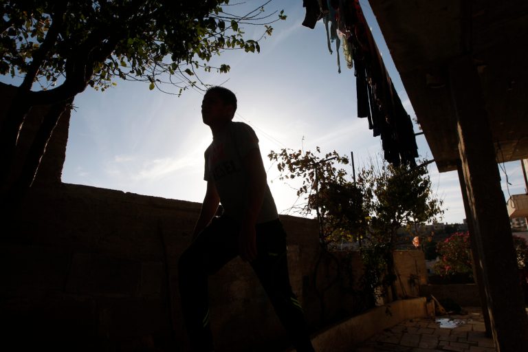 In this Sunday, Nov. 3, 2013 photo, a Palestinian boy walks around his home in the village of Beit Ummar near the West Bank city of Hebron. At the age of 15, the boy was held for nine months in an Israeli military jail for throwing rocks at passing Israeli cars near his village in the West Bank. An Israeli 15-year-old boy was arrested for a similar crime at the same time but faced a different justice system. The Israeli boy refused to allow his photo to be taken. (AP Photo/Majdi Mohammed)