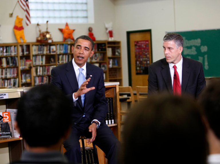 Education Secretary Arne Duncan looks on as President Obama talks to students at Wakefield High School in Arlington, Va., in September 2009. (AP Photo/Gerald Herbert)