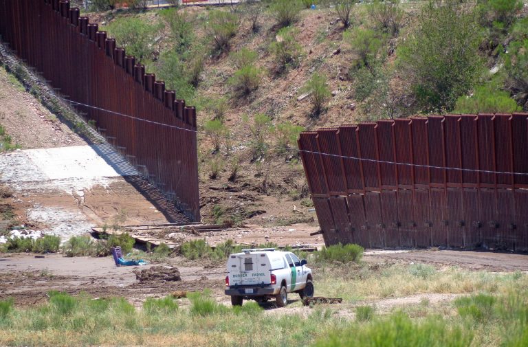 A border patrol vehicle stands guard at a section of collapsed fence just west of the Mariposa Port of Entry in Nogales, Ariz., Sunday. (AP/Nogales International, Jonathan Clark)