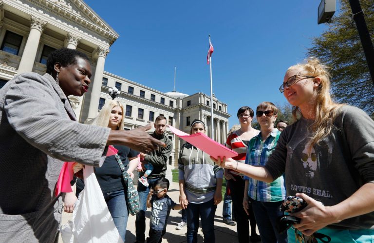 Patricia Ice, an attorney with the Mississippi Immigrants Rights Alliance, left, hands out flyers to Jordan Sanders of Vicksburg, that call for the freeing of 22-year old Daniela Vargas, a Argentine native who has lived in the United States since she was seven years old, following a brief rally on her behalf, at the Capitol in Jackson, Miss., Friday, March 3, 2017, Vargas was detained, March 1, by immigration agents who state that she is a 