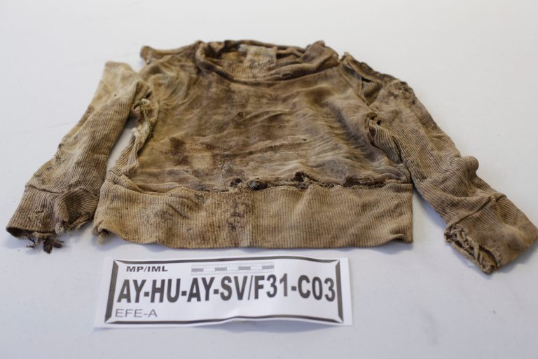 A shirt that belonged to a person who was exhumed from a mass grave at the Los Cabitos army base in Ayacucho province is displayed for the press at the Public Ministry in Lima, Peru, Tuesday, Sept. 9, 2014. According to prosecutors, the clothes displayed on Tuesday belonged to 53 civilians who were allegedly slain by soldiers during Peru's two-decade-long conflict that claimed nearly 70,000 lives. Government prosecutors have opened one case against soldiers who worked at the Los Cabitos army base base between 1983 and 1996. (AP Photo/Martin Mejia)