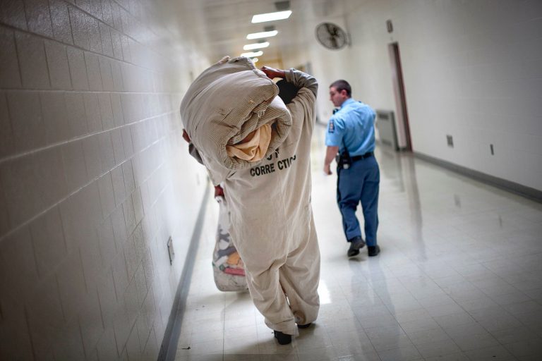 A prisoner carries a mattress as he moves through the state prison Thursday, March 3, 2011 in Jackson, Ga.(AP Photo/David Goldman)