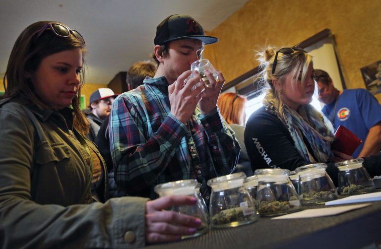 Customers, left to right, Alli Bertucci, Patrick Bean, and  Ali Regan shop for marijuana inside the retail store at 3D Cannabis Center, in Denver, Friday Feb. 14, 2014. The marijuana industry breathed a sigh of relief Friday after federal banking regulators issued long-awaited permission for them to access basic banking services. (AP Photo/Brennan Linsley)