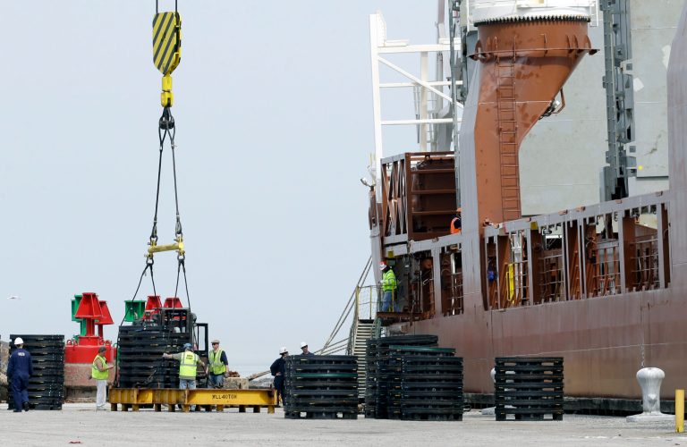 In this Monday, April 21, 2014 photo, workers load materials for export onto the Amsterdam-bound Fortunagracht at the Port of Cleveland in Cleveland. A drop in U.S. exports and lower income from overseas investments drove the U.S. current account deficit to its highest level in 18 months, the Commerce Department reported Wednesday, June 18, 2014. (AP Photo/Tony Dejak)