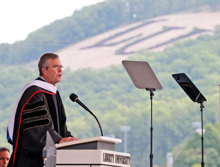 Former Florida Gov. Jeb Bush, at podium, delivers the commencement address at Liberty University in Williams Stadium at the school in Lynchburg, Va., Saturday, May 9, 2015. (AP Photo/Steve Helber)