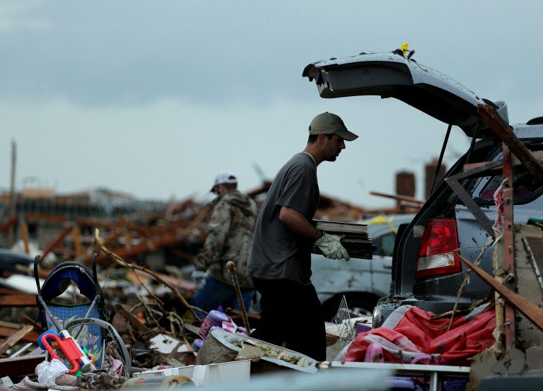 Justin Stehan salvages photographs from his tornado-ravaged home in Moore, Okla., on Tuesday. (Photo: Charlie Riedel/AP)