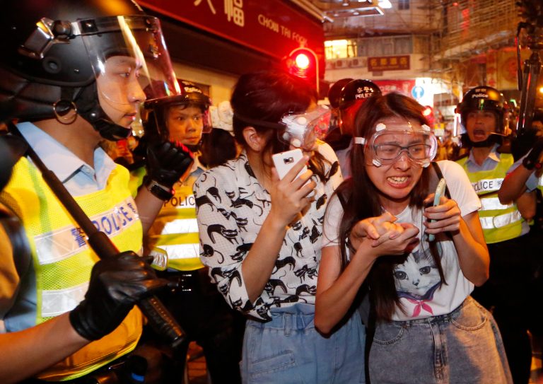 Protesters cry as some of the protesters are beaten by riot police in the occupied area in the Mong Kok district of Hong Kong, early Saturday, Oct. 18, 2014. New scuffles broke out Friday night between Hong Kong riot police and pro-democracy activists in a district where police cleared protesters earlier in the day.  (AP Photo/Kin Cheung)