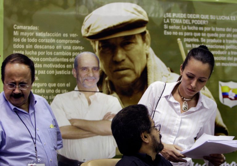   Members of the negotiating team for Colombia's Revolutionary Armed Forces of Colombia, or FARC, from left, Andres Paris, Ivan Marquez, Tanja Nijmeijer talk before giving a press conference on the sidelines of peace talks with Colombia's government in Havana, Cuba, Friday, Dec. 21, 2012. The government delegation and the FARC issued a joint statement saying negotiations will resume Jan. 14. The poster behind shows late FARC leader Manuel Marulanda, center right, and Jaime Palmera, center left, who is serving time in the U.S. federal penitentiary in Florence, Colorado. (AP Photo/Franklin Reyes)  