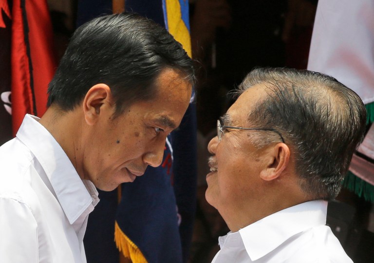 Indonesian presidential candidate Joko Widodo, left,  congratulates his running mate Jusuf Kalla after declaring their candidacy for the upcoming presidential election in Jakarta, Indonesia, Monday, May 19, 2014. Widodo has chosen former Vice President Jusuf Kalla as his running mate, a pick likely to strengthen an already formidable ticket. Indonesia will hold its presidential election on July 9. (AP Photo/Dita Alangkara)