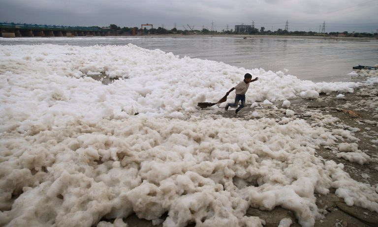 A young boy runs amidst polluted water of the river Yamuna in New Delhi, India, Friday, Oct. 4, 2013. (AP Photo/Saurabh Das)