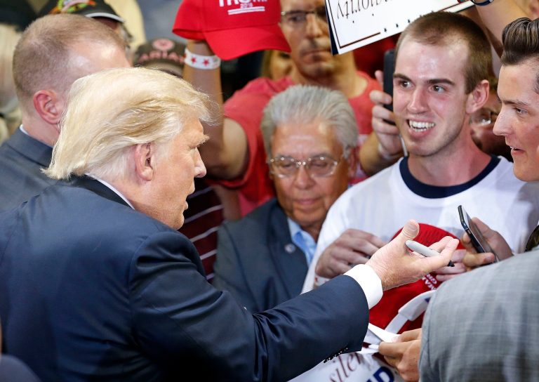 Republican presidential candidate Donald Trump talks to supporters as he signs autographs after speaking at a rally Saturday, June 18, 2016, in Phoenix. (AP Photo/Ross D. Franklin)