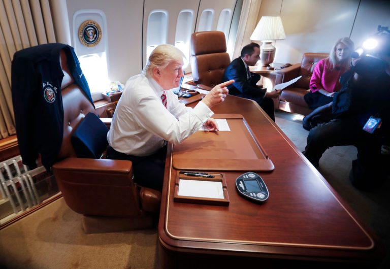 President Trump points to members of the media while sitting at his desk on Air Force One upon his arrival at Andrews Air Force Base. At the center seated is Trump's Chief of Staff Reince Priebus. Adviser Kellyanne Conway is at right. (AP Photo/Pablo Martinez Monsivais)
