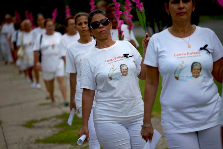 FILE - In this Oct. 14, 2012 file photo, members of Cuba's Ladies in White dissident group, wearing T-shirts with images of late co-founder of the group, Laura Pollan, participate in a march marking one year since the death of Pollan in Havana, Cuba. Members of Cuba's Ladies in White opposition group will finally pick up Europe's top human rights prize from 2005 in person next week in Belgium, the EU and the daughter of the group's former leader said Wednesday. (AP Photo/Ramon Espinosa, File)