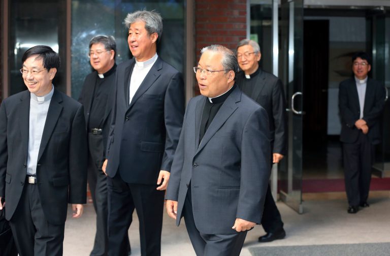 South Korean Roman Catholic Cardinal Andrew Yeom Soo-jung, center, leaves for an inter-Korean joint factory park in Kaesong, North Korea, at Myeong-dong Cathedral in Seoul, South Korea, Wednesday, May 21, 2014. Seoul's Unification Ministry says Cardinal Andrew Yeom is making a one-day visit Wednesday to the joint North-South factory park at Kaesong, North Korea, to tour the complex and meet South Koreans working there.(AP Photo/Yonhap, Park Dong-ju) KOREA OUT