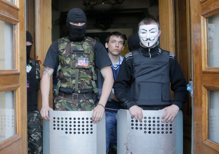 Masked pro-Russian activists guard the entrance during their mass storming of a regional Television Centre in Donetsk, Ukraine, Sunday, April 27, 2014.  Insurgents in Slovyansk have taken a number of people hostage, including journalists and pro-Ukraine activists, as they strengthen their control in the east of the country in defiance of the interim government in Kiev and its Western supporters. (AP Photo/Efrem Lukatsky)