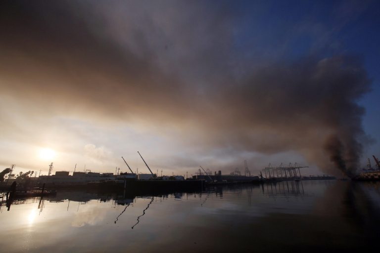 A plume of smoke rises from a dock fire at the Port of Los Angeles in the Wilmington section of Los Angeles on Tuesday, Sept 23, 2014. The Los Angeles Fire Department says a spark from a welder's torch caused the fire that forced about 850 workers to evacuate the area Monday night. (AP Photo/ Nick Ut )