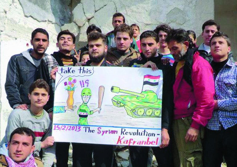 This citizen journalism image provided by Edlib News Network, ENN, which has been authenticated based on its contents and other AP reporting, shows anti-Syrian regime protesters holding a caricature placard during a demonstration, at Kafr Nabil town, in Idlib province, northern Syria, Friday, Feb. 15, 2013. Heavy fighting for control of the international airport in the northern Syrian city of Aleppo and a major military air base nearby has killed some 150 rebels and government soldiers over the past two days, activists said Friday. (AP Photo/Edlib News Network ENN)