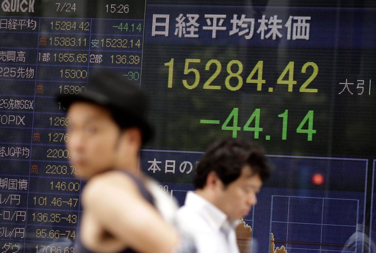 Men walk by an electronic stock board of a securities firm in Tokyo, Thursday, July 24, 2014. Asian shares were subdued Thursday despite an improvement in Chinaâs manufacturing as a wait-and-see mood prevailed ahead of earnings reports from some of the regionâs top companies. (AP Photo/Eugene Hoshiko)