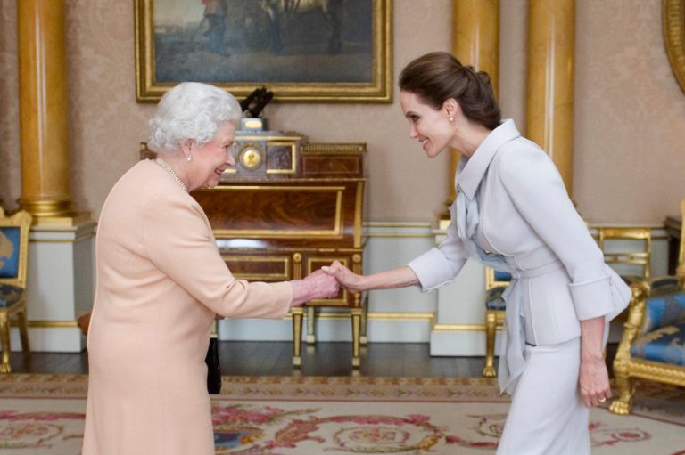 U.S actress Angelina Jolie, right, is presented with the Insignia of an Honorary Dame Grand Cross of the Most Distinguished Order of St Michael and St George by Britain's Queen Elizabeth II at Buckingham Palace, London, Friday, Oct. 10, 2014. Jolie received an honorary damehood (DCMG) for services to UK foreign policy and the campaign to end war zone sexual violence. (AP Photo/Anthony Devlin, pool)